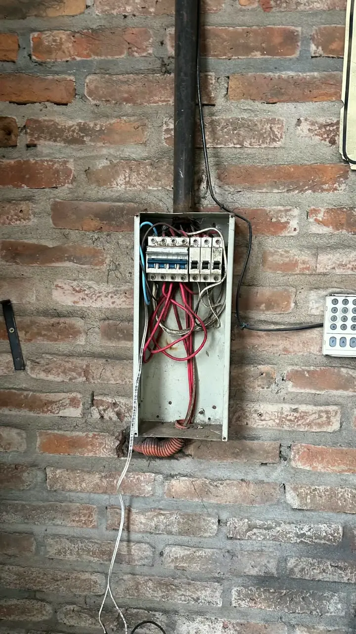 Tablero original abierto, con cables sueltos y sin orden