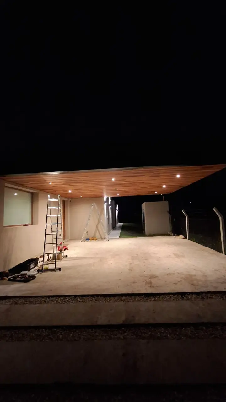 Garage terminado de noche, con las dicroicas LED cálidas encendidas en el cielorraso de madera